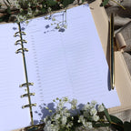 Open planner with a pen and flowers. Planner shows a hourly schedule and task list. 