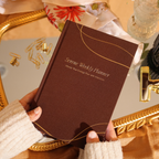 Brown planner held by a person with decorative background