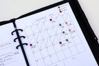 Calendar page in a planner with color-coded notes on a white background