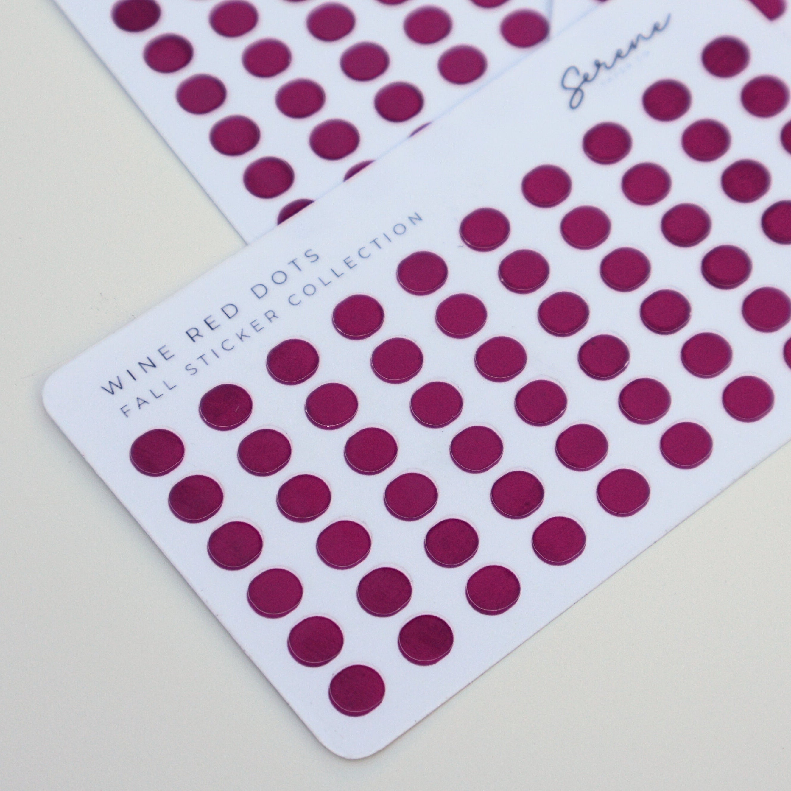 Wine red dot stickers on a white card 
