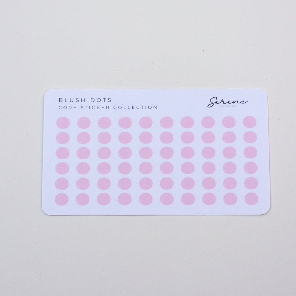 Sheet of pink dot stickers on a light gray background