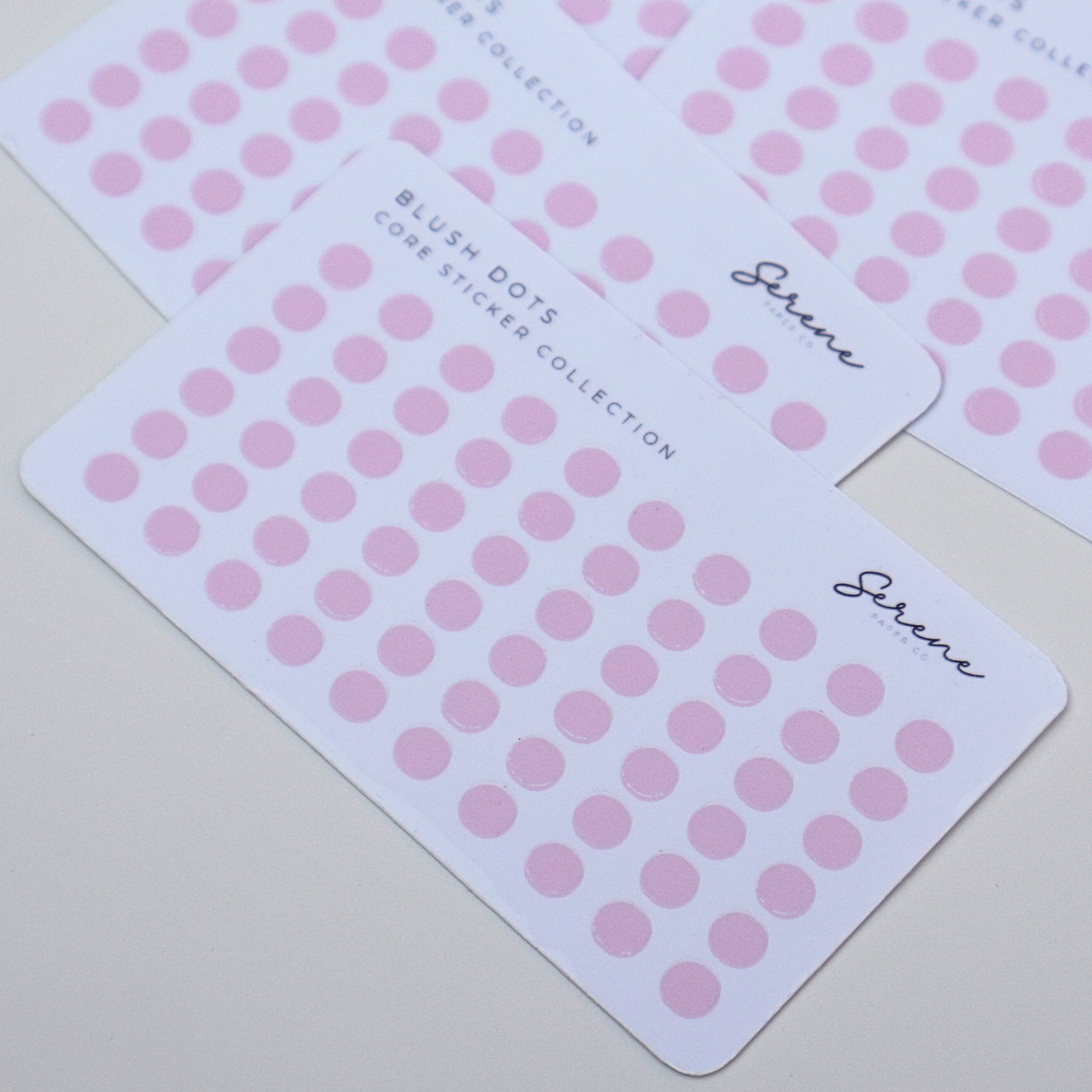 Pink dot stickers on white cards with Serene branding on a light gray background