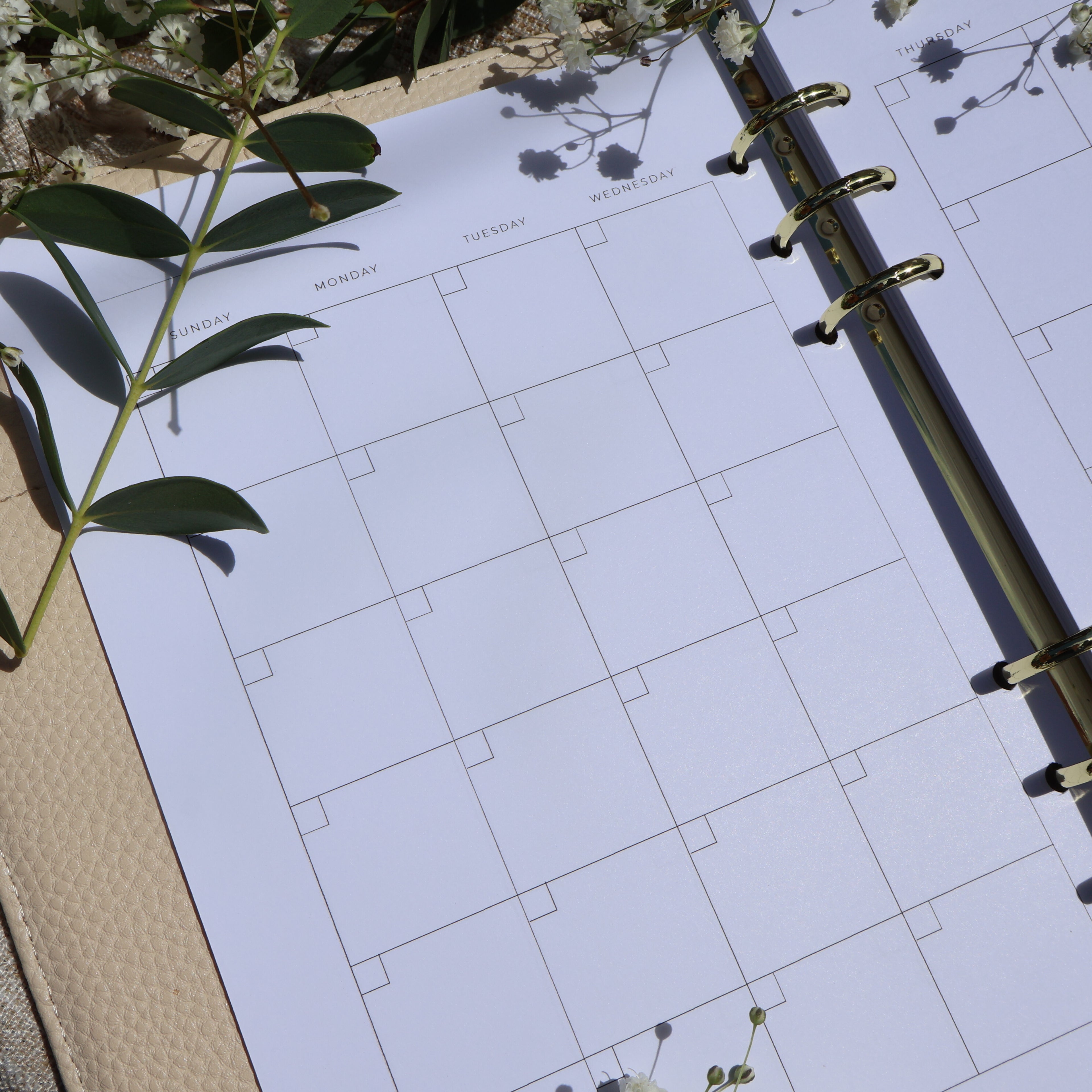 Planner monthly calendar close up shot. has florals surrounding it. 