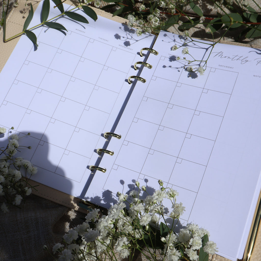 Open planner with floral decorations on a light surface