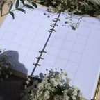 Open planner with floral decorations on a light surface