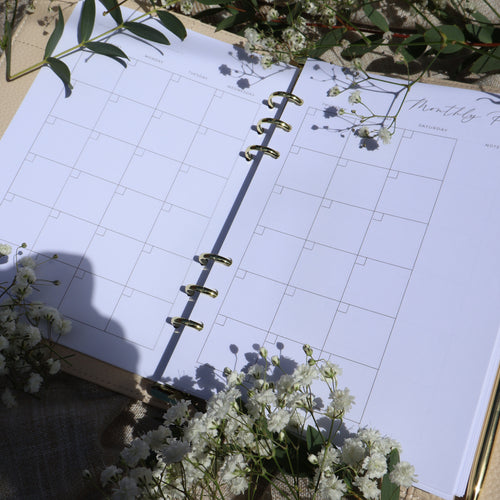 Open planner with floral decorations on a light surface