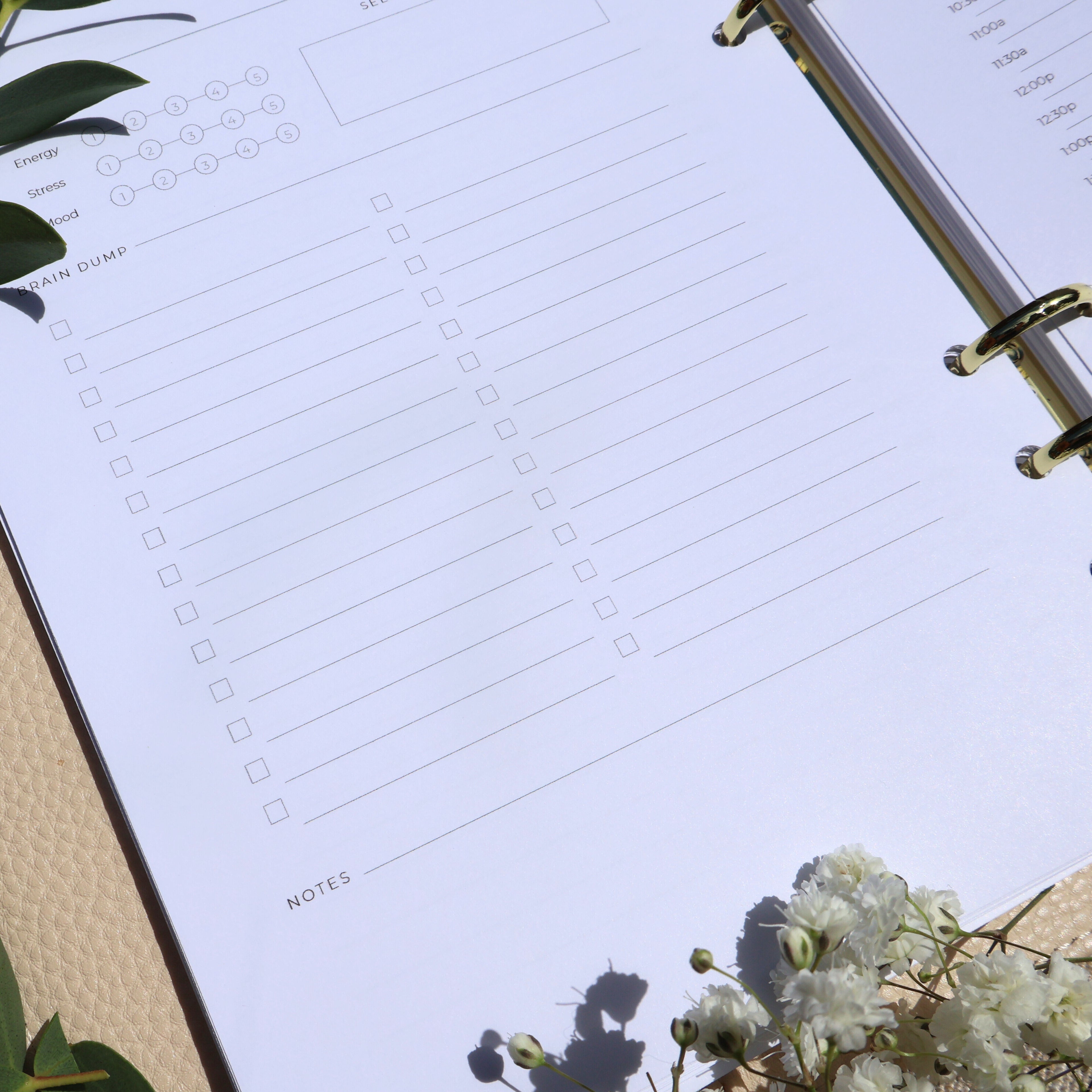 Planner with checklists and a floral arrangement on a light surface