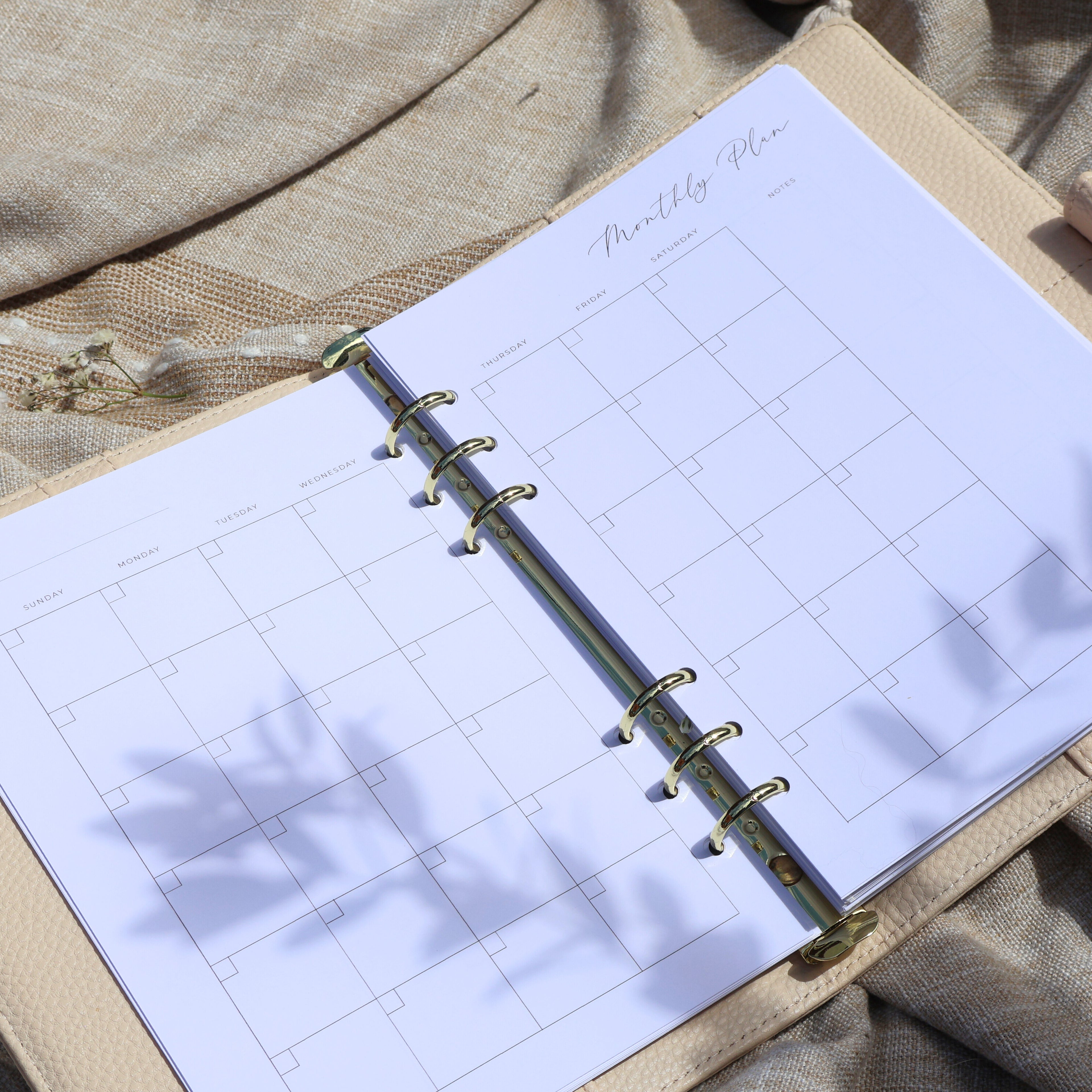 Open planner with monthly plan on beige fabric background