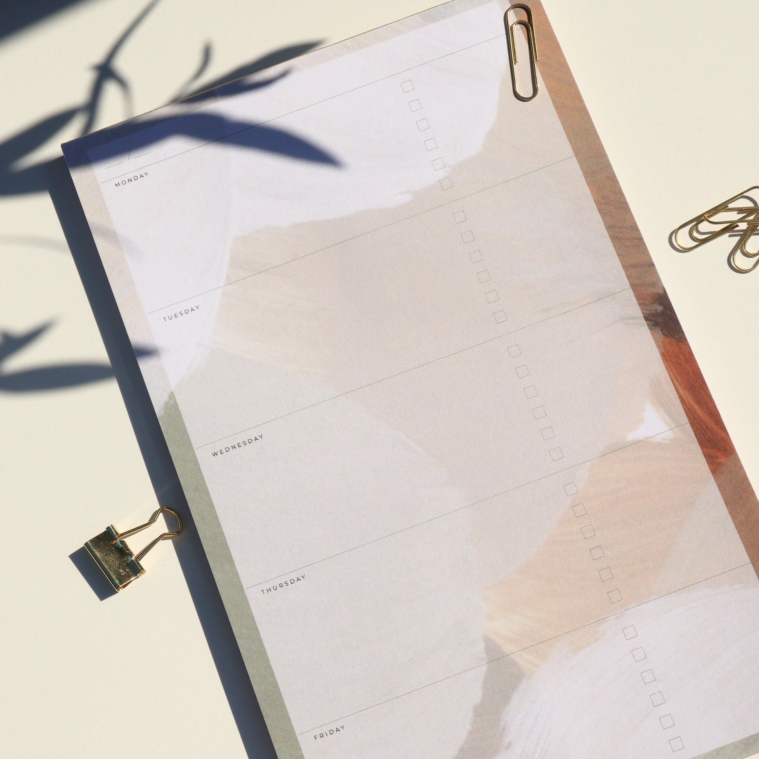 Notebook with a pen holder and clips on a light background