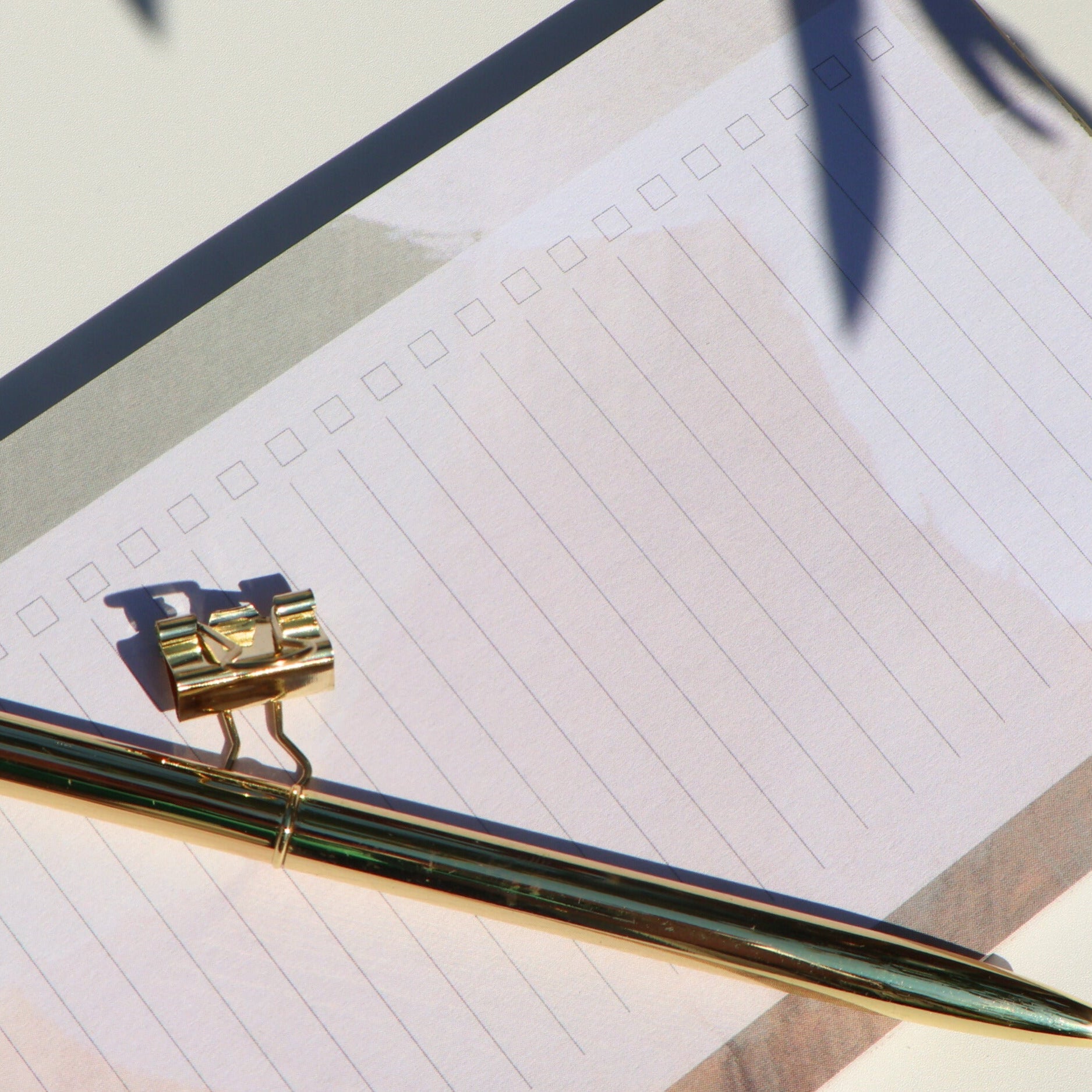 Gold pen with a decorative clip on a piece of paper