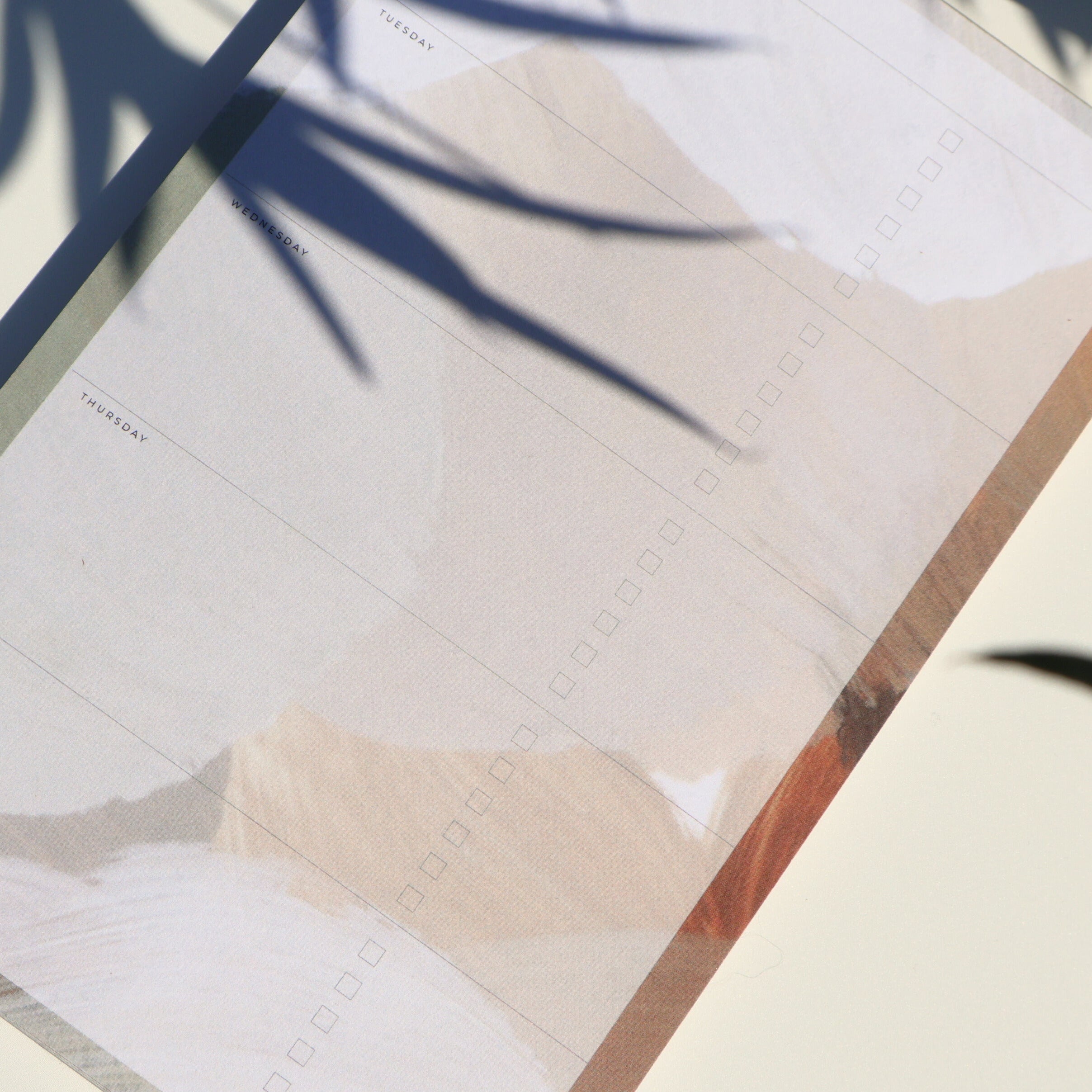 Close-up of a notebook with a pen on a light surface
