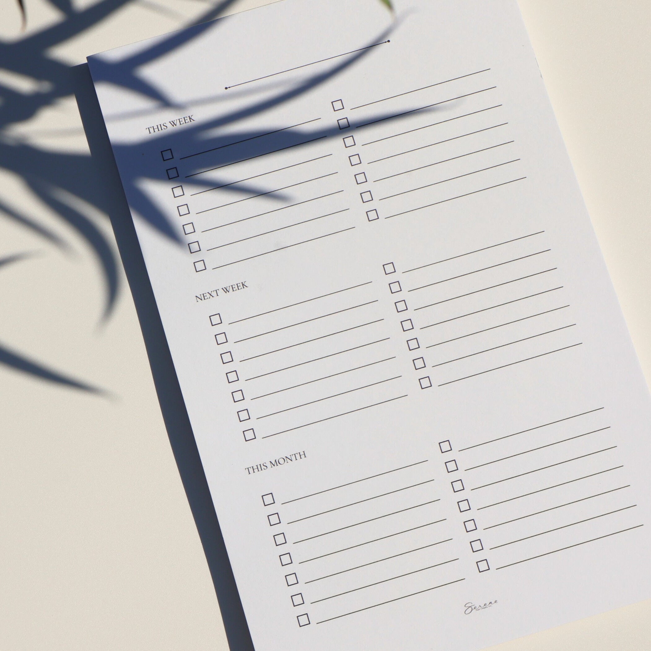 Checklist paper with shadows of plants on a light background