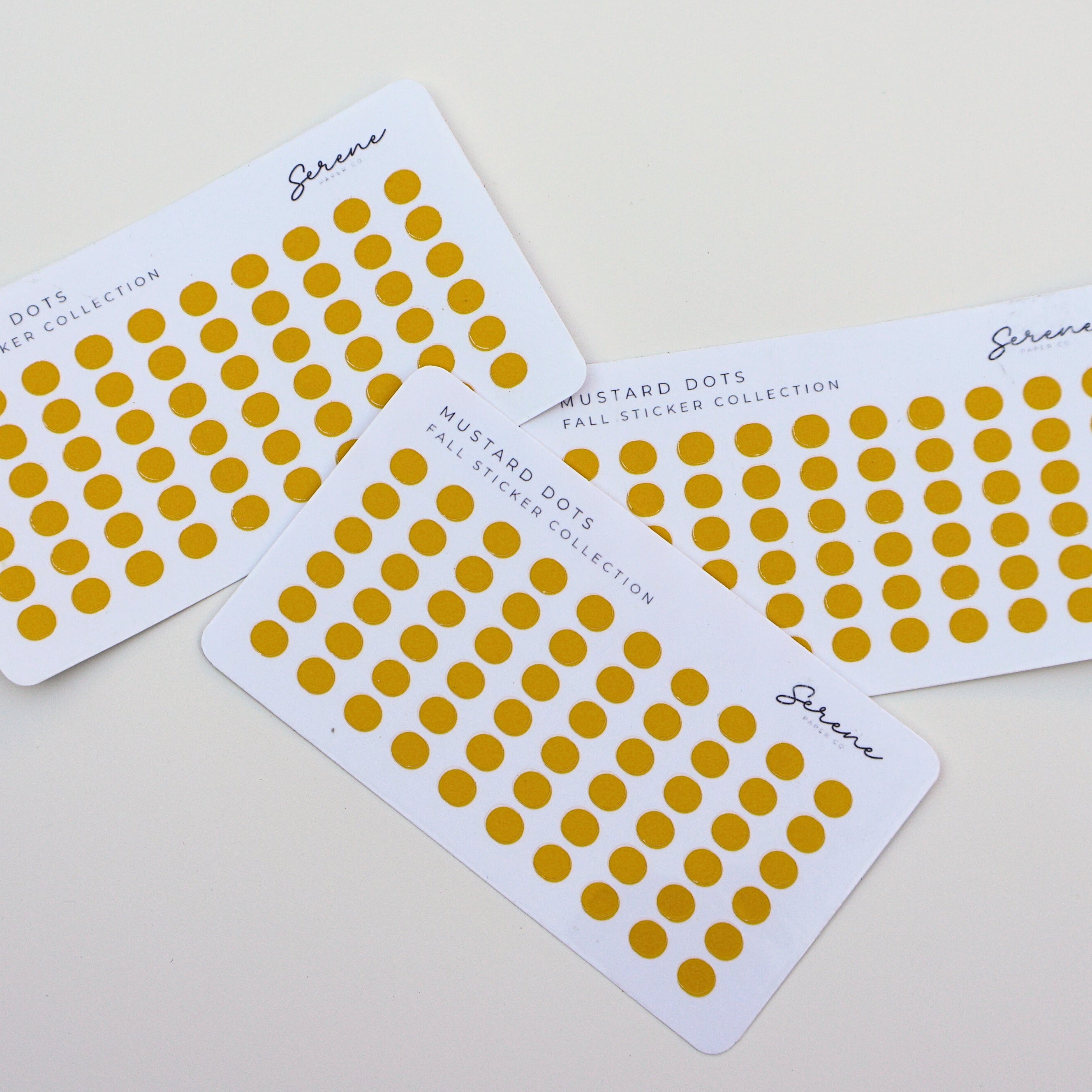 Four sheets of yellow dot stickers on a light gray background