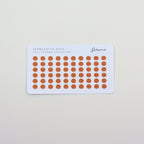 Sheet of orange stickers with a white border on a light gray background