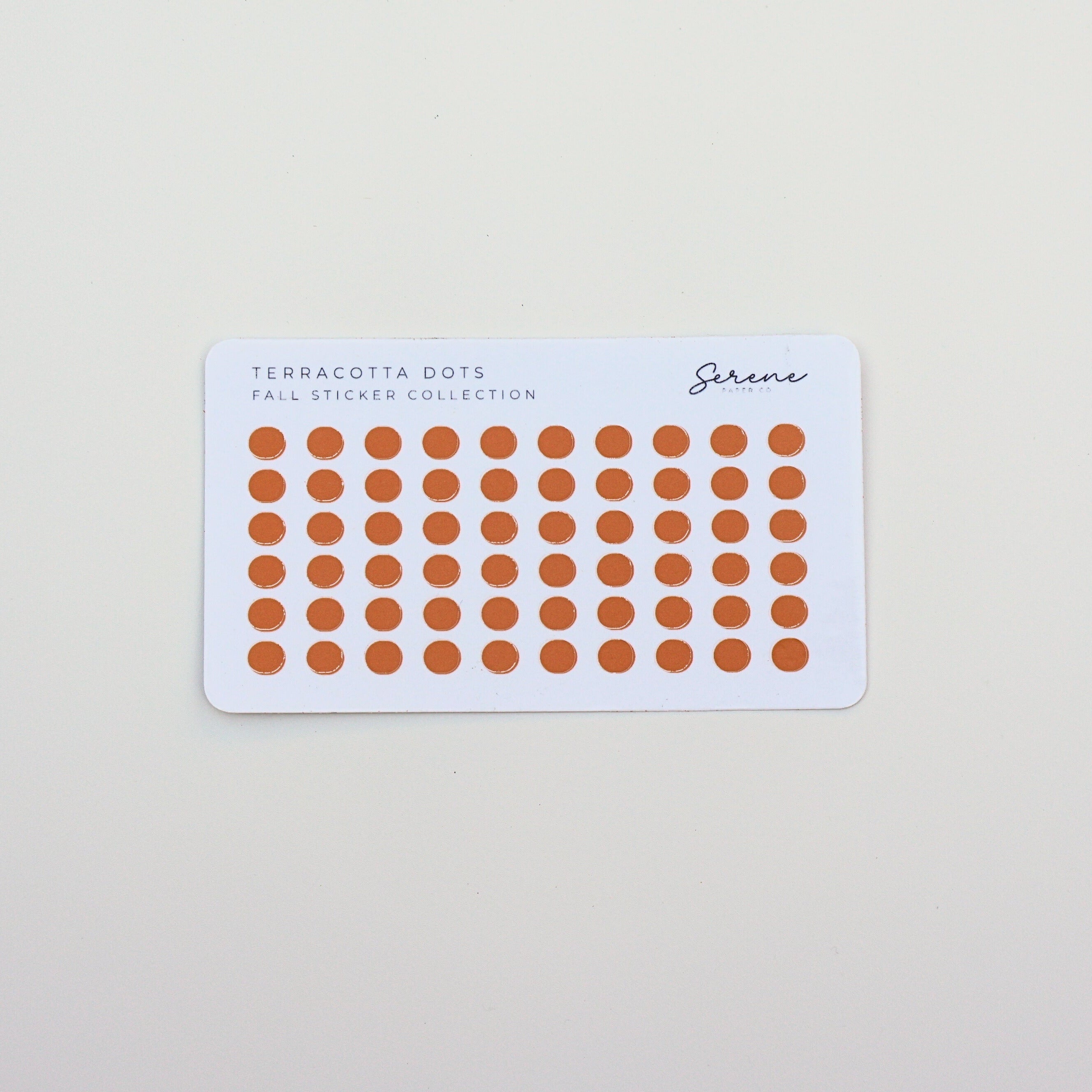 Sheet of orange stickers with a white border on a light gray background