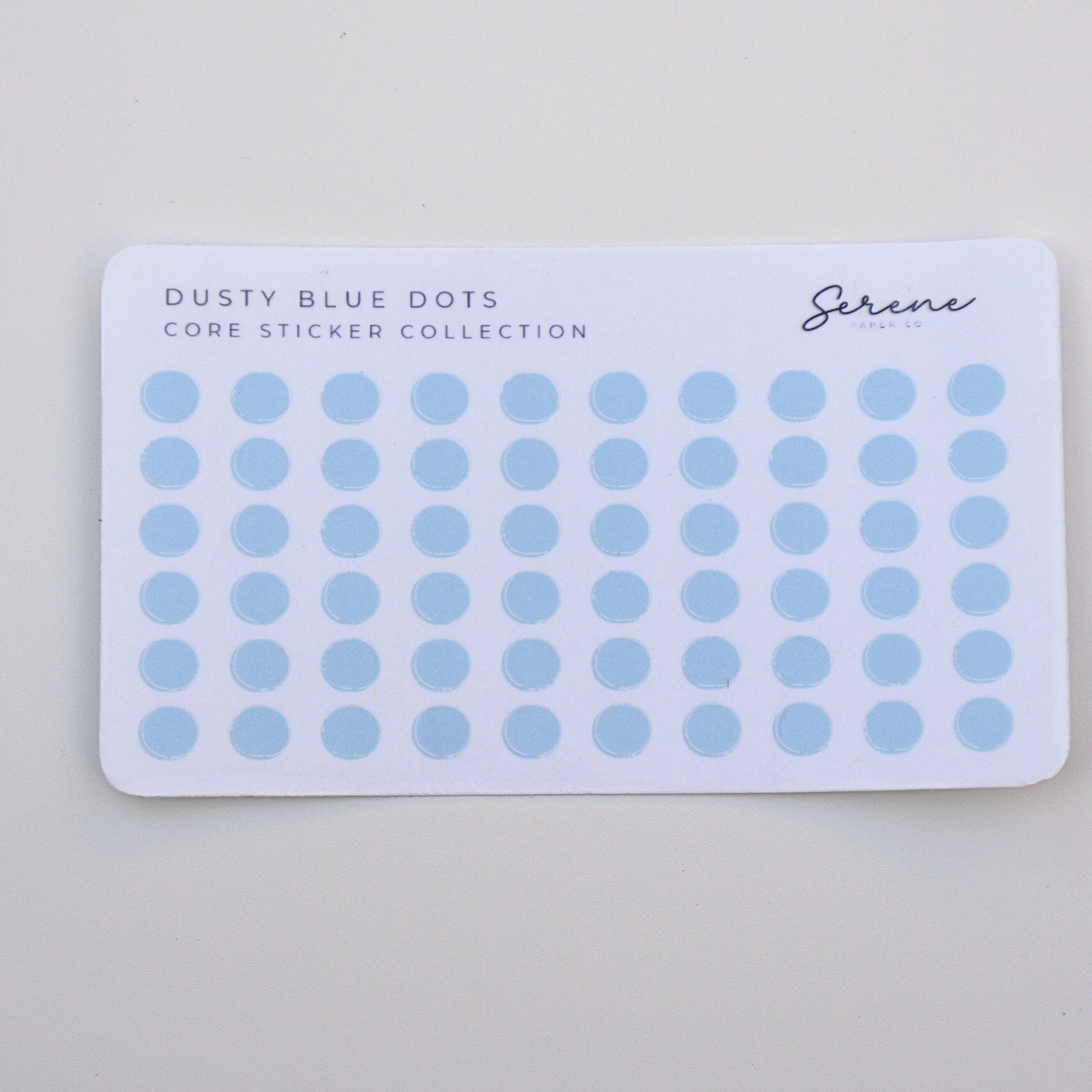 Card with dusty blue dot stickers on a light gray background