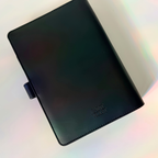 Black notebook with a brand logo on a gradient background