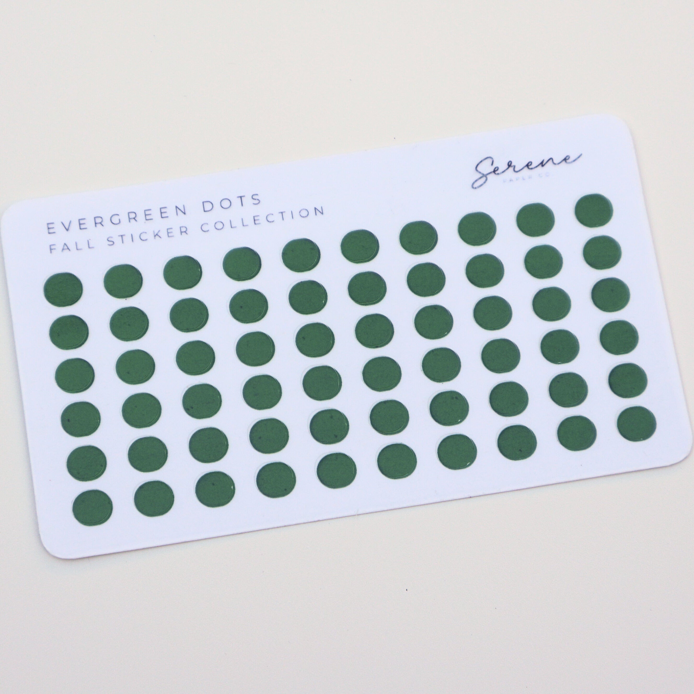 Card with green dot stickers labeled 'Evergreen Dots' on a beige background