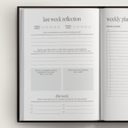 Open planner with reflection and weekly planning pages on a light gray background